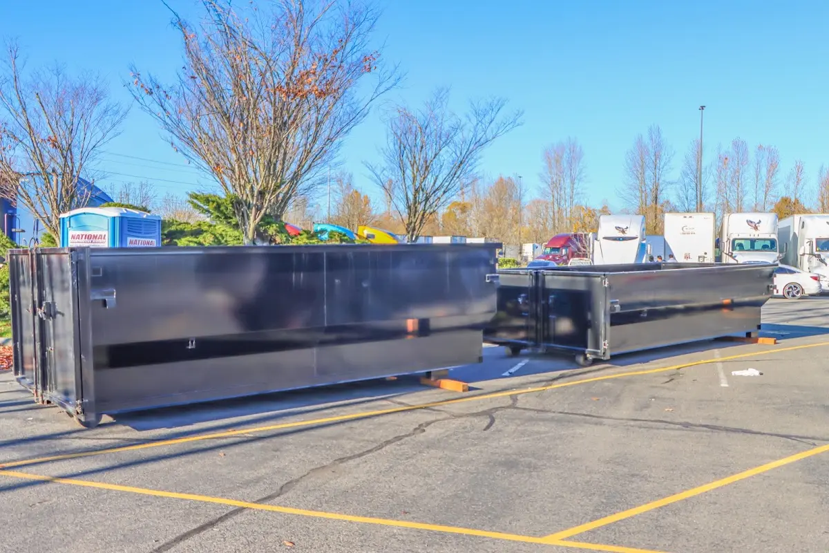 Professional dumpster rental service with roll-off container on residential driveway in Tuskegee